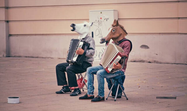 Two people dressed in horse costumes playing instruments